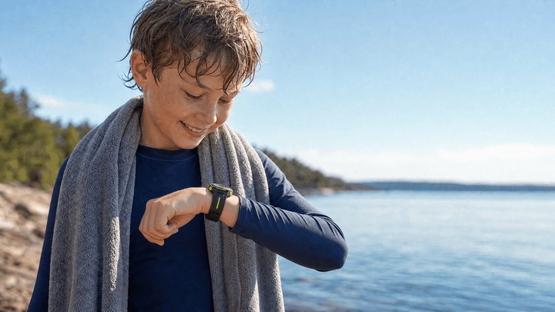 Barn med digital klokke etter aktivitet ved vann